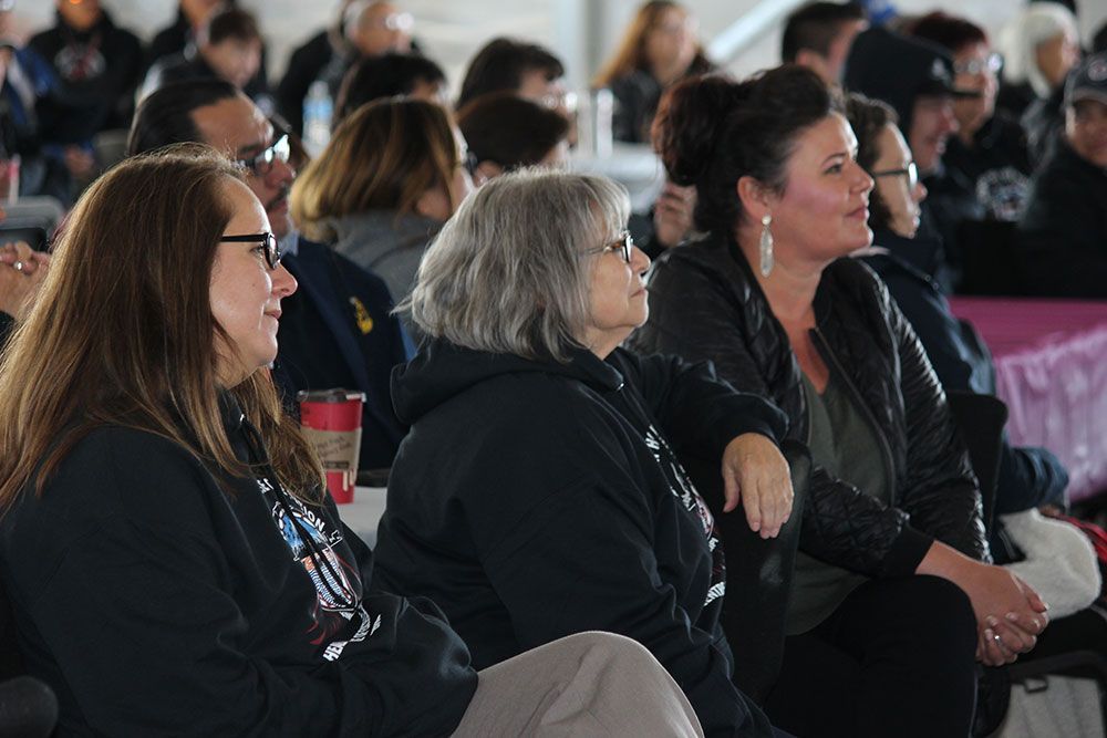 A group of people are sitting in a room watching a presentation.