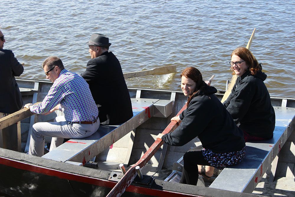 A group of people are rowing a boat on a lake.