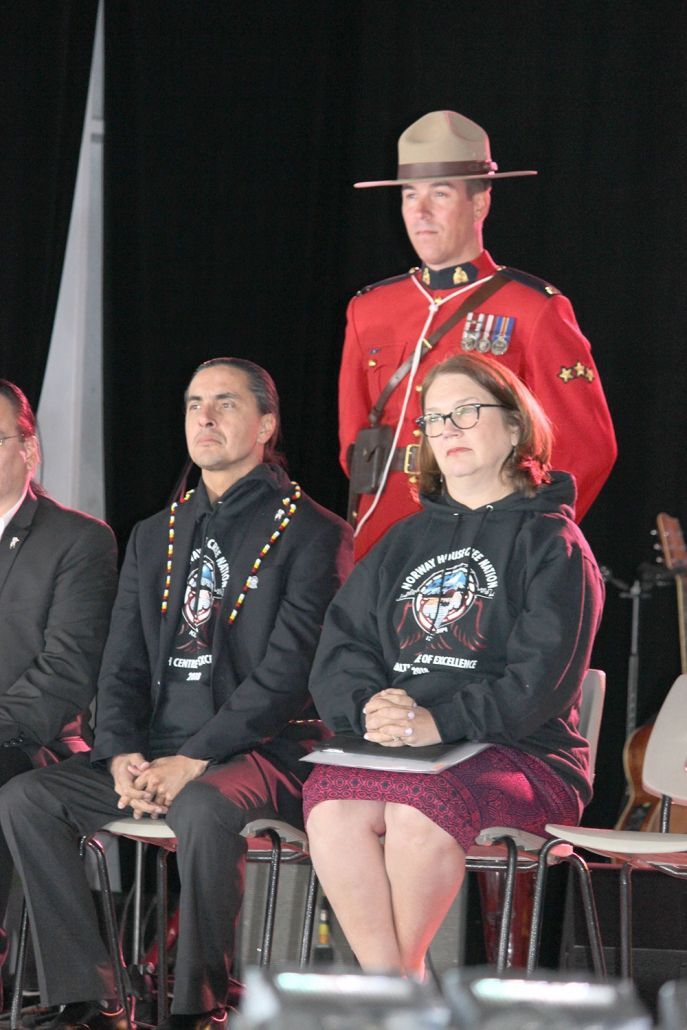 A man in a red uniform is standing in front of a group of people