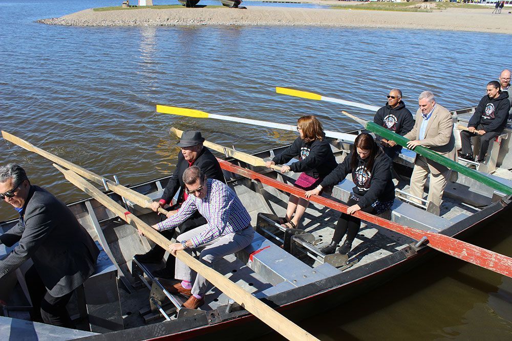 A group of people are rowing a boat in the water.