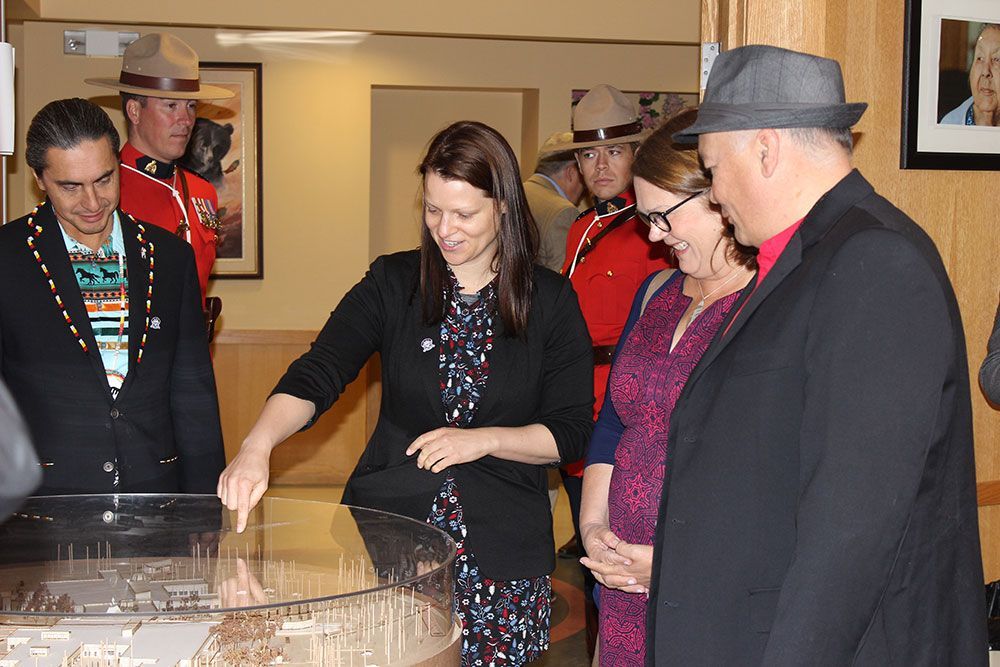 A group of people are looking at a model of a city.