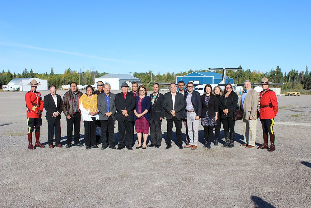 A group of people posing for a picture in front of a plane