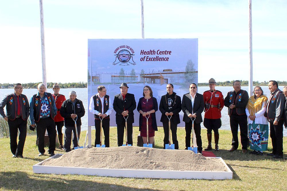 A group of people are standing next to each other in front of a sign.