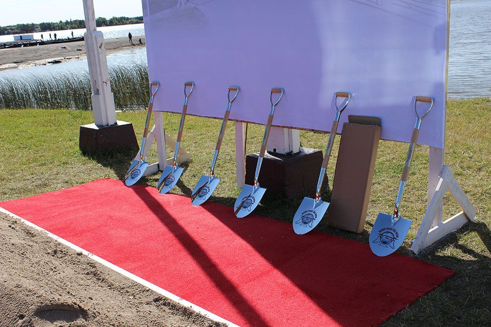 A row of shovels are lined up on a red carpet