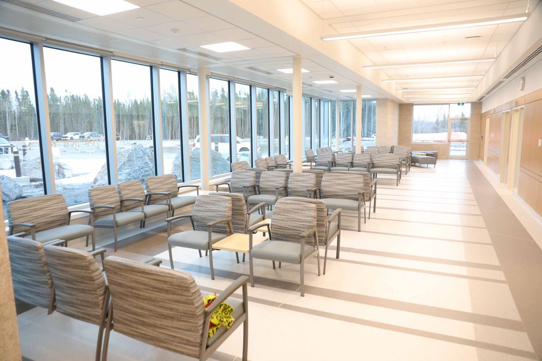 There are a lot of chairs in the waiting room of a hospital.