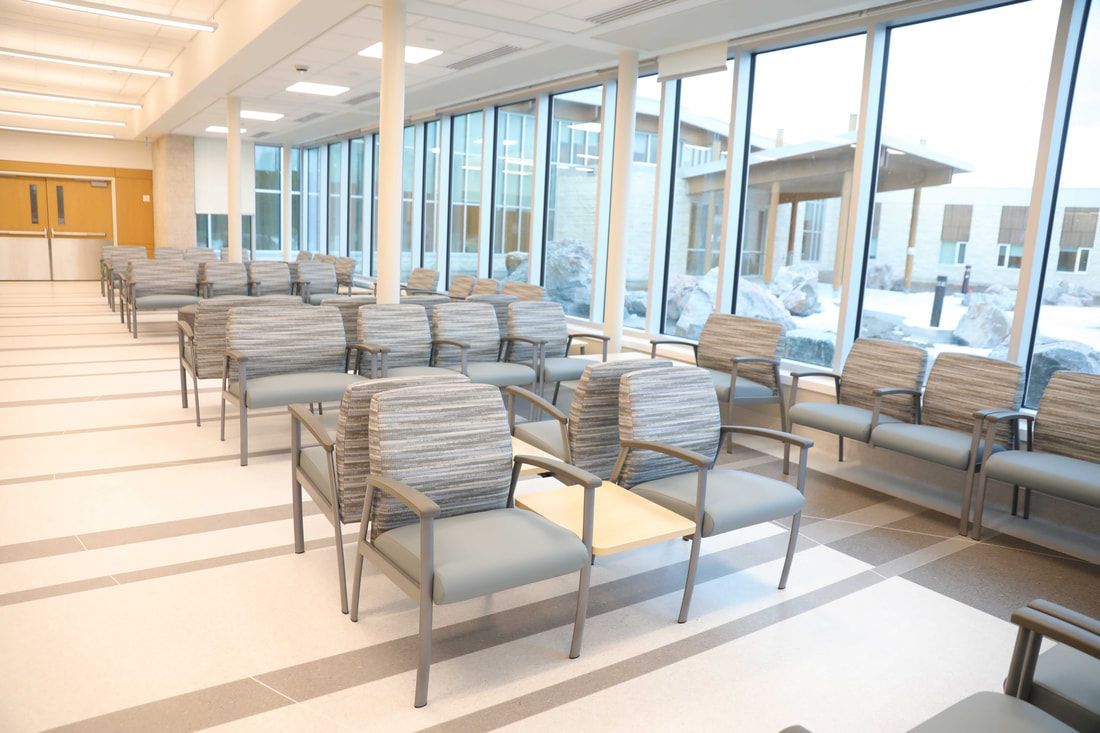There are a lot of chairs in the waiting room of a hospital.