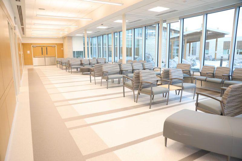 There are a lot of chairs in the waiting room of a hospital.
