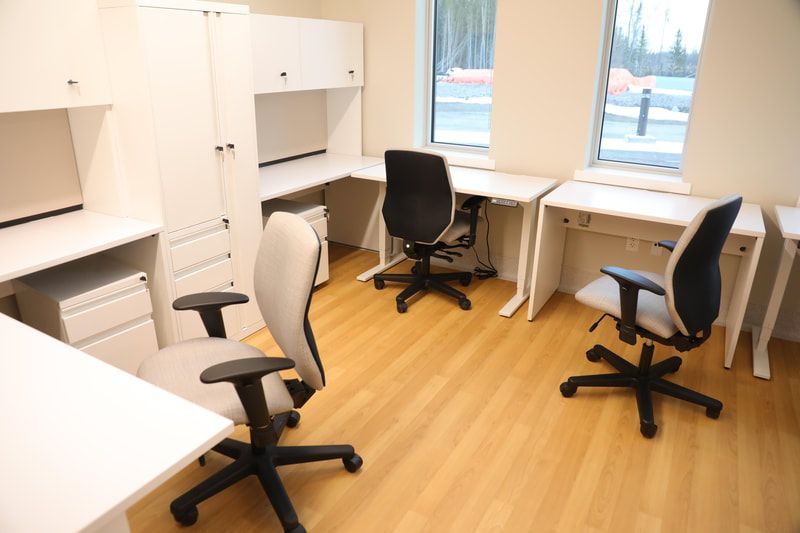 A room with three desks and three chairs in it