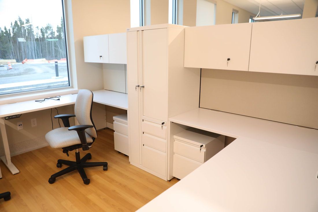 A room with two desks and a chair in it