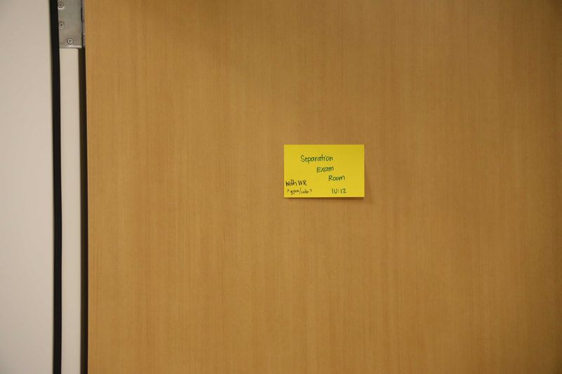 A yellow sticky note is stuck to a wooden door.