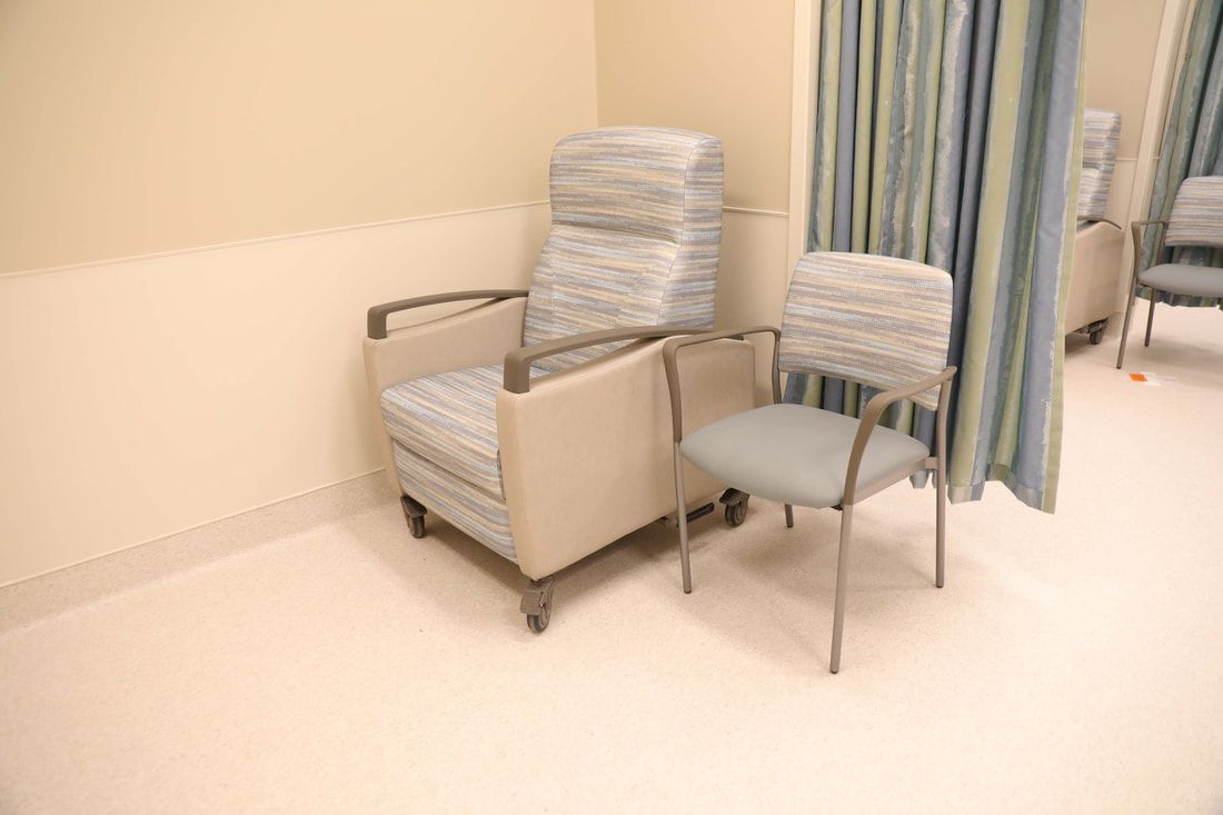 A hospital room with two chairs and a curtain.