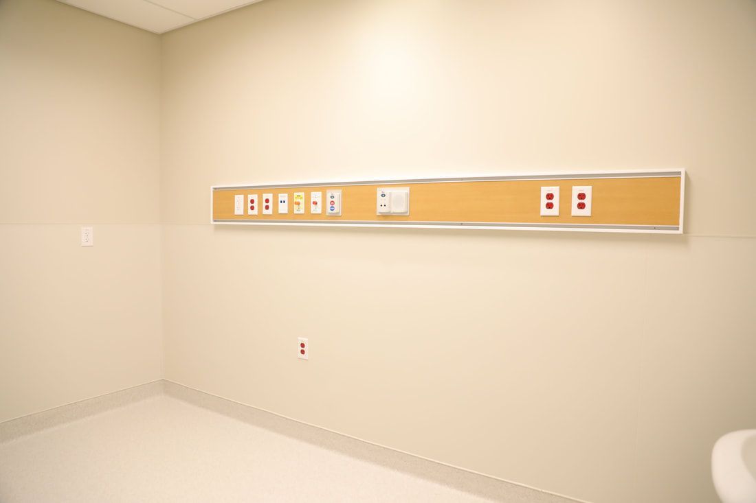 An empty hospital room with a sign on the wall.