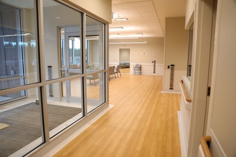 A long hallway with wooden floors and lots of windows