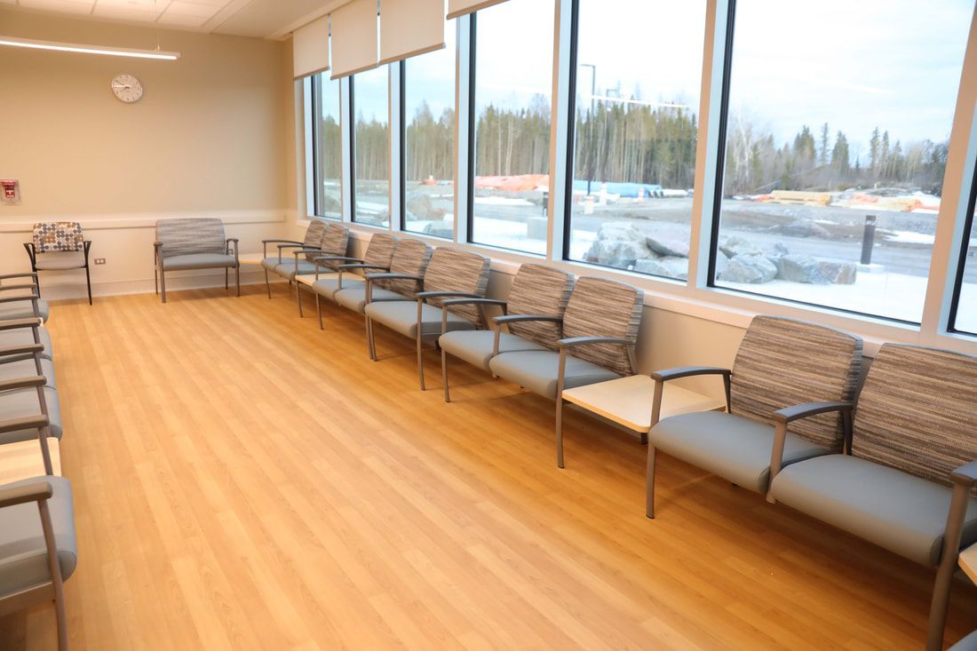 A waiting room with a lot of chairs and windows.