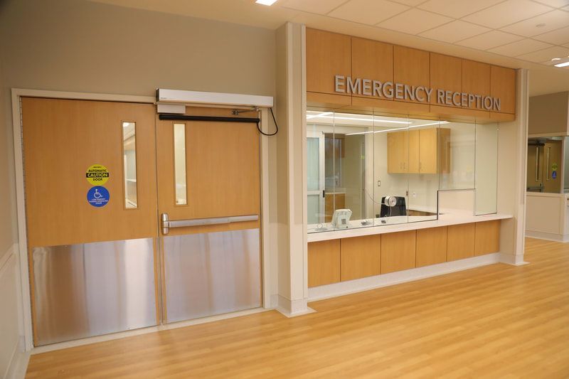 An emergency room in a hospital with a sliding door and a counter.