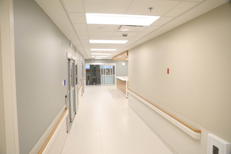 An empty hospital hallway with a sliding glass door