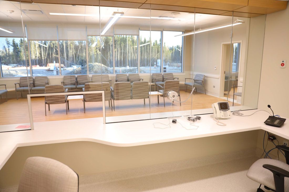 A waiting room in a hospital with a desk and chairs