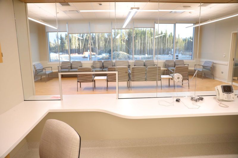 A waiting room in a hospital with a desk and chairs.