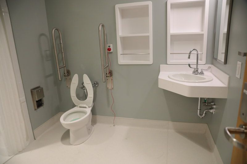 A bathroom with a toilet , sink and shower.