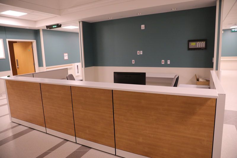 A hospital reception area with a wooden counter and a computer.