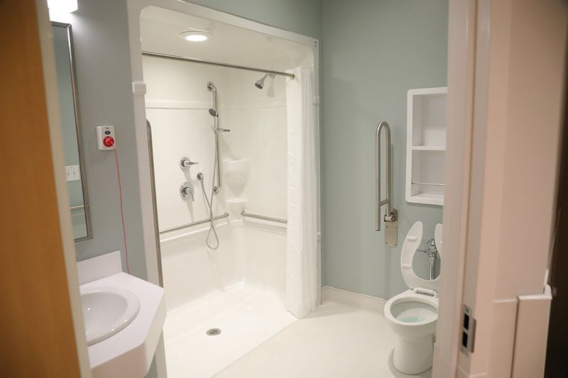 A bathroom with a toilet , sink and shower.