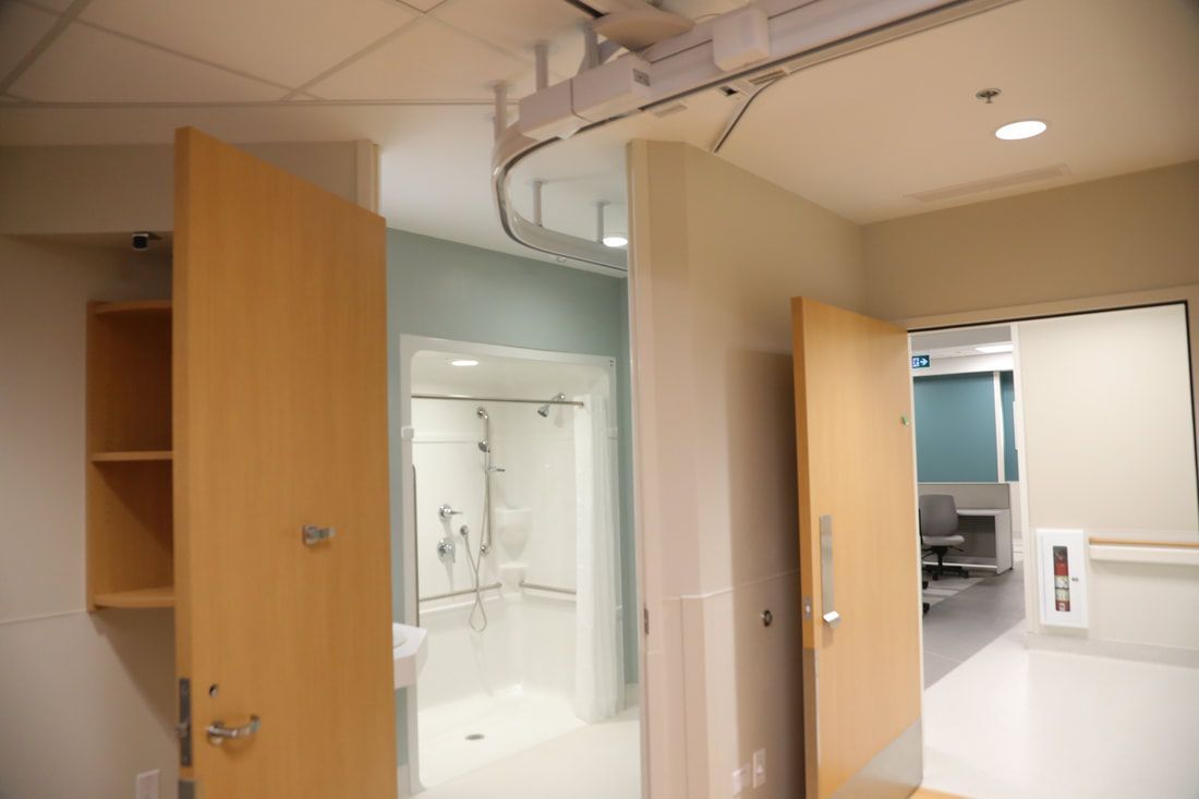 A hospital room with a shower and a sink