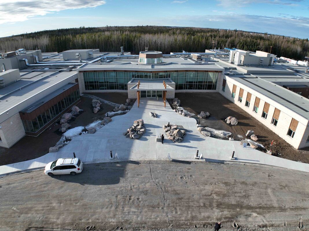 An aerial view of a large building with a car parked in front of it.