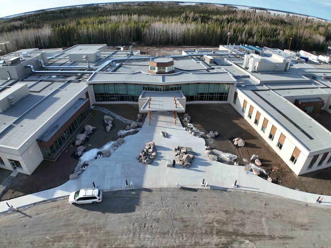 An aerial view of a large building with a car parked in front of it.