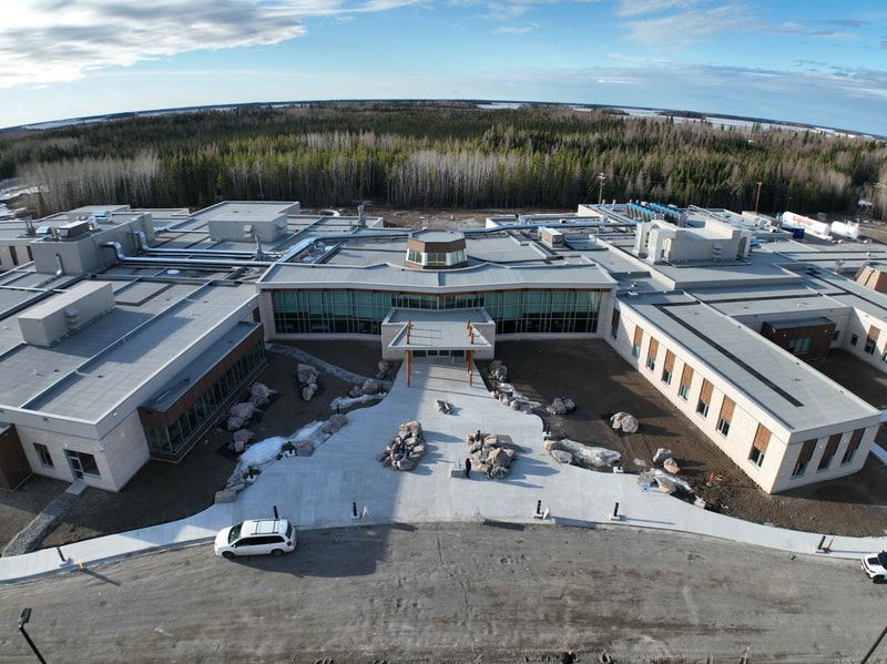 An aerial view of a large building with cars parked in front of it.