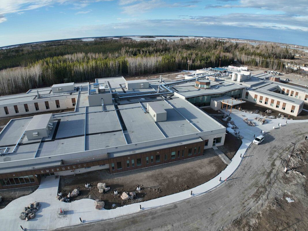 An aerial view of a large building in the middle of a forest.