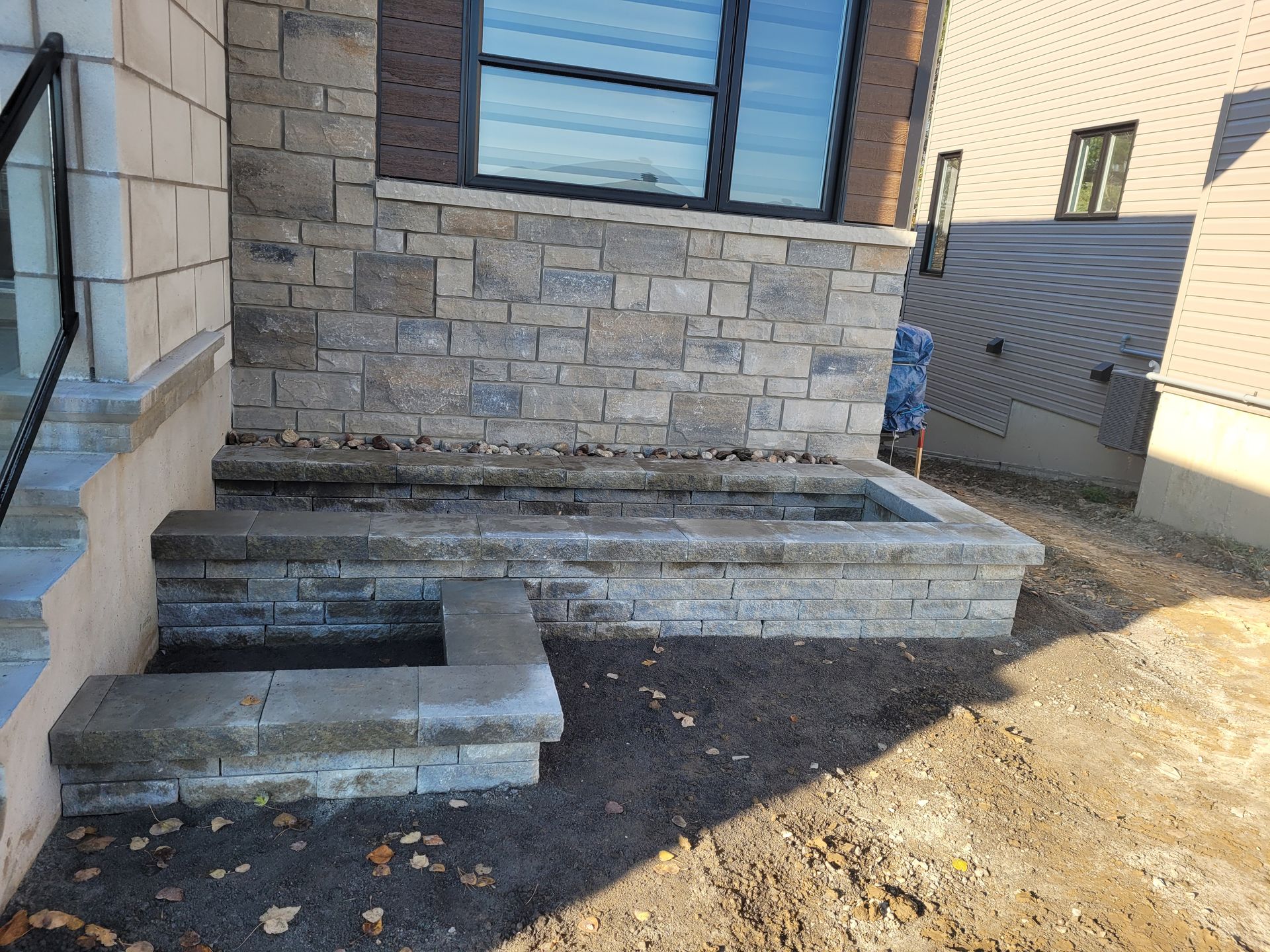 Stone steps leading up to a building with a stone facade and large window.