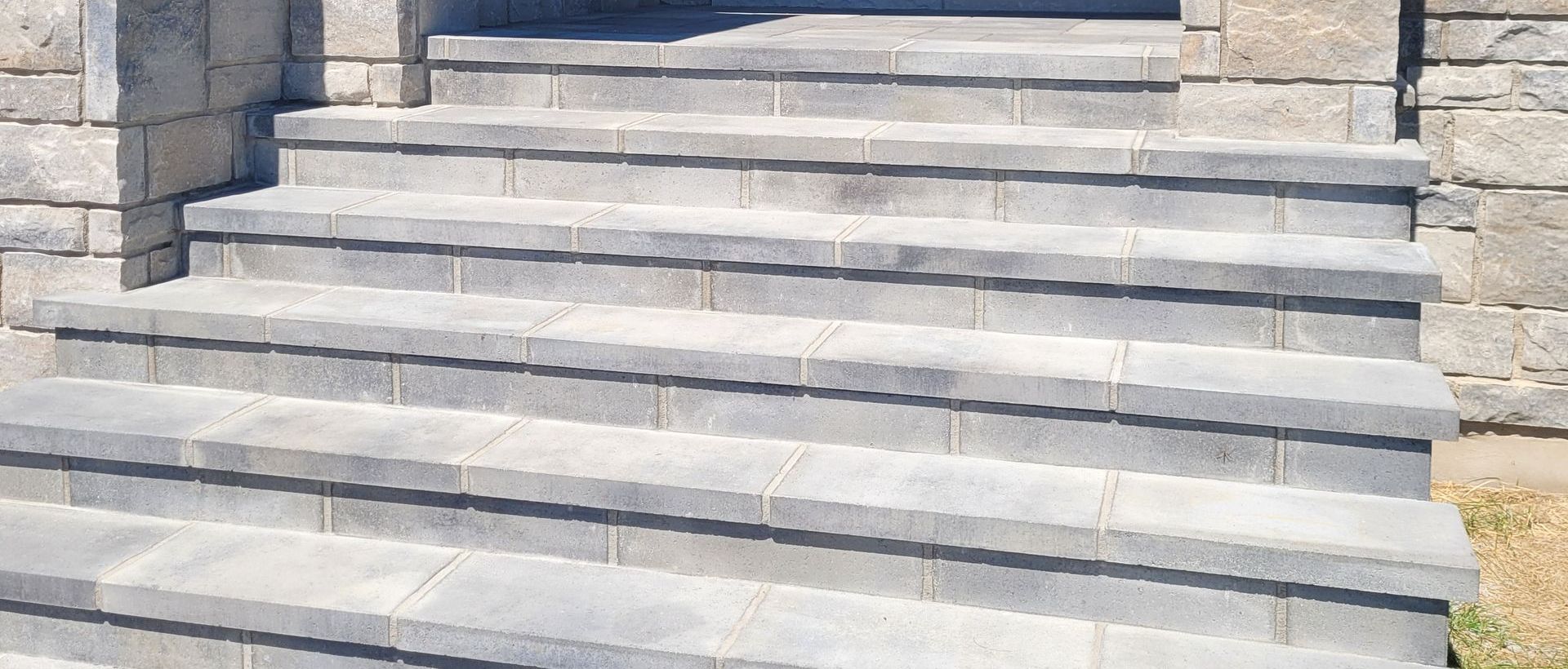 Stone steps leading up to a building entrance. Gray brick facade on either side.