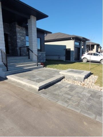 Gray paver walkway and steps leading to modern home's entrance. Fire pit on the right.