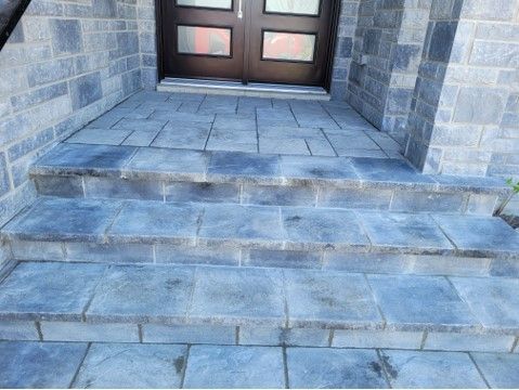 Stone steps leading up to a brown door with matching stone walls.
