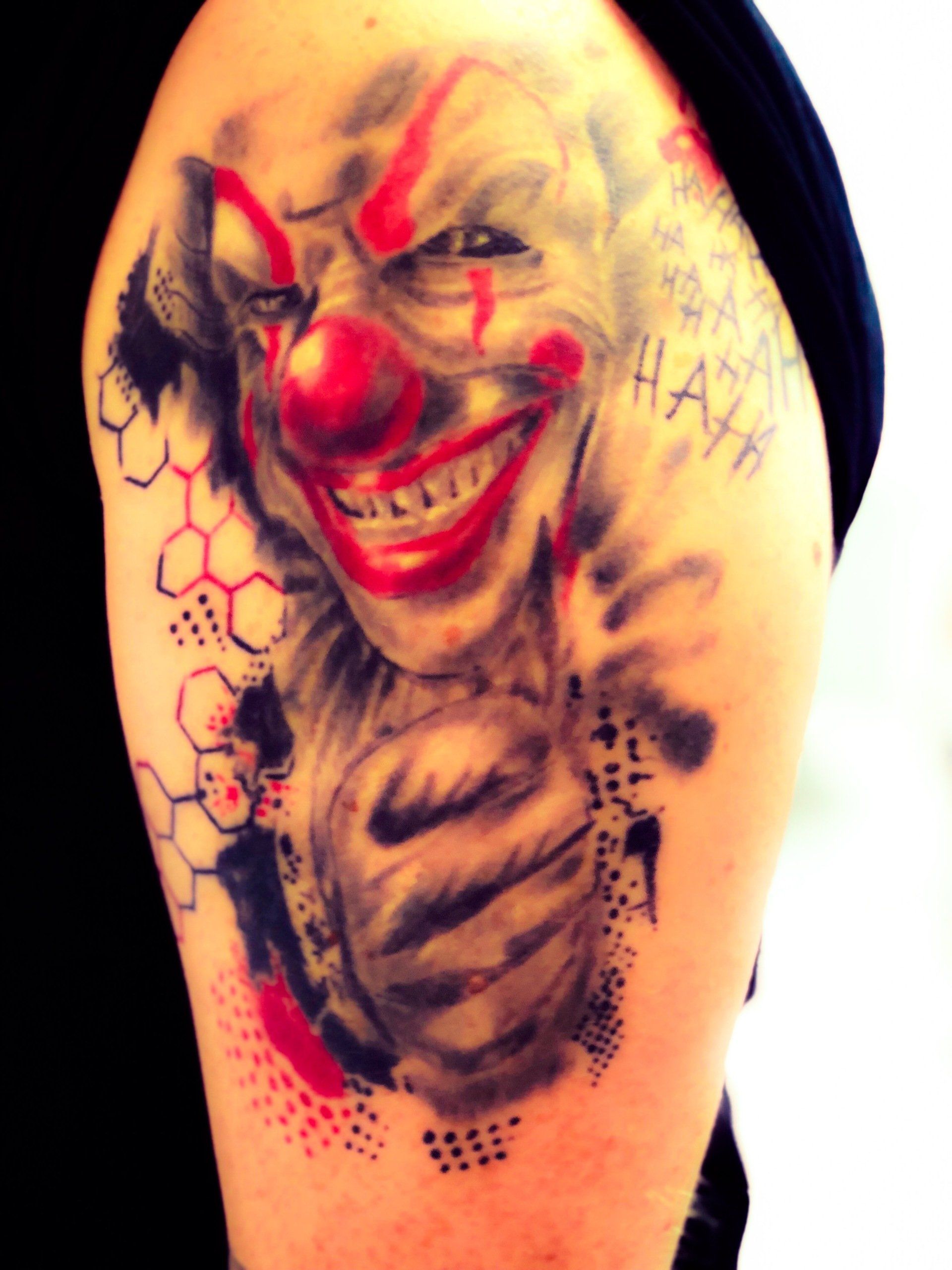 Eine Person hat eine Clown-Tätowierung auf dem Arm