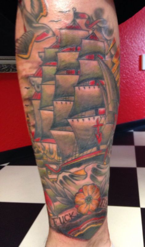 Ein Mann hat eine Schiffstätowierung auf seinem Bein.