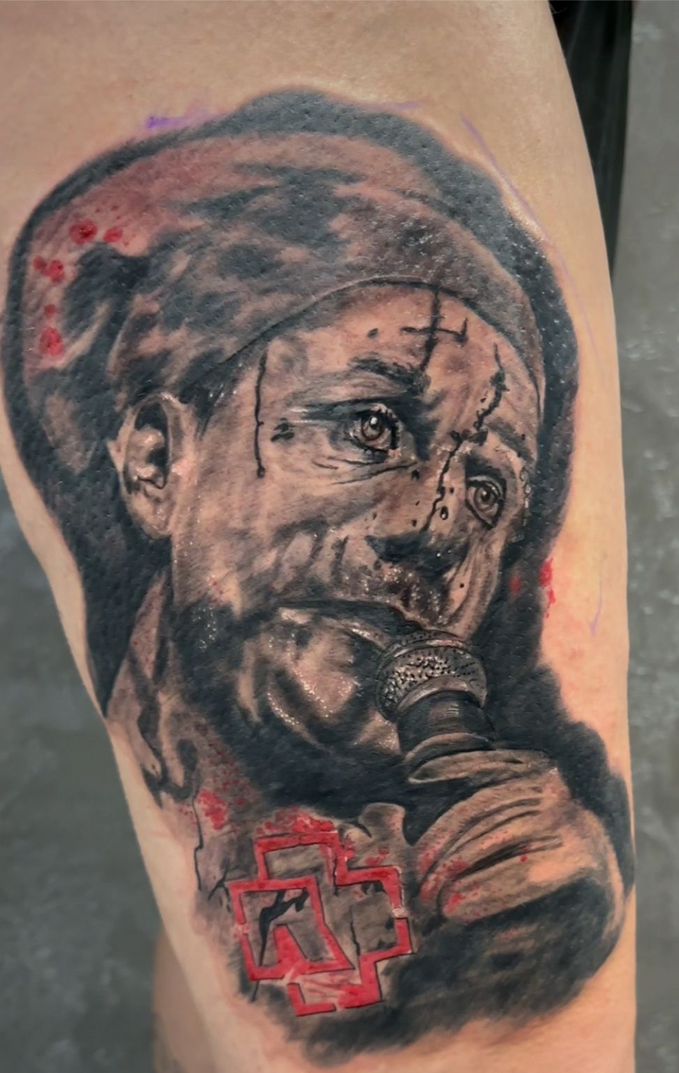 Eine Nahaufnahme einer Tätowierung eines Mannes, der ein Mikrofon hält