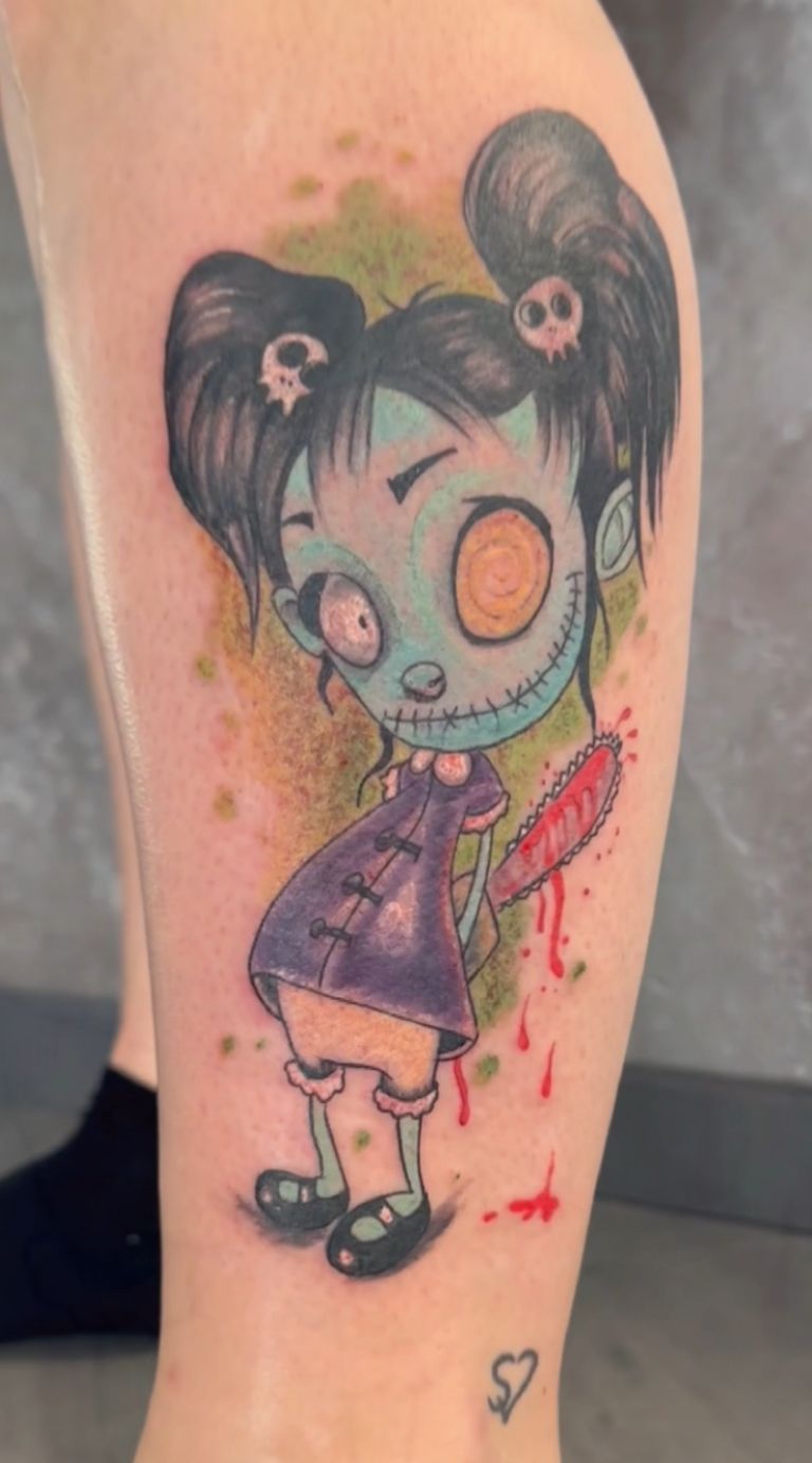 Eine Person hat ein Tattoo eines Zombie-Mädchens auf ihrem Bein.