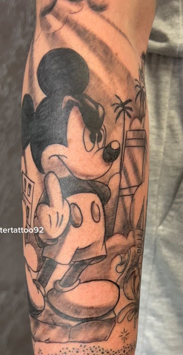 Eine Person hat eine Mickey-Mouse-Tätowierung auf dem Bein.