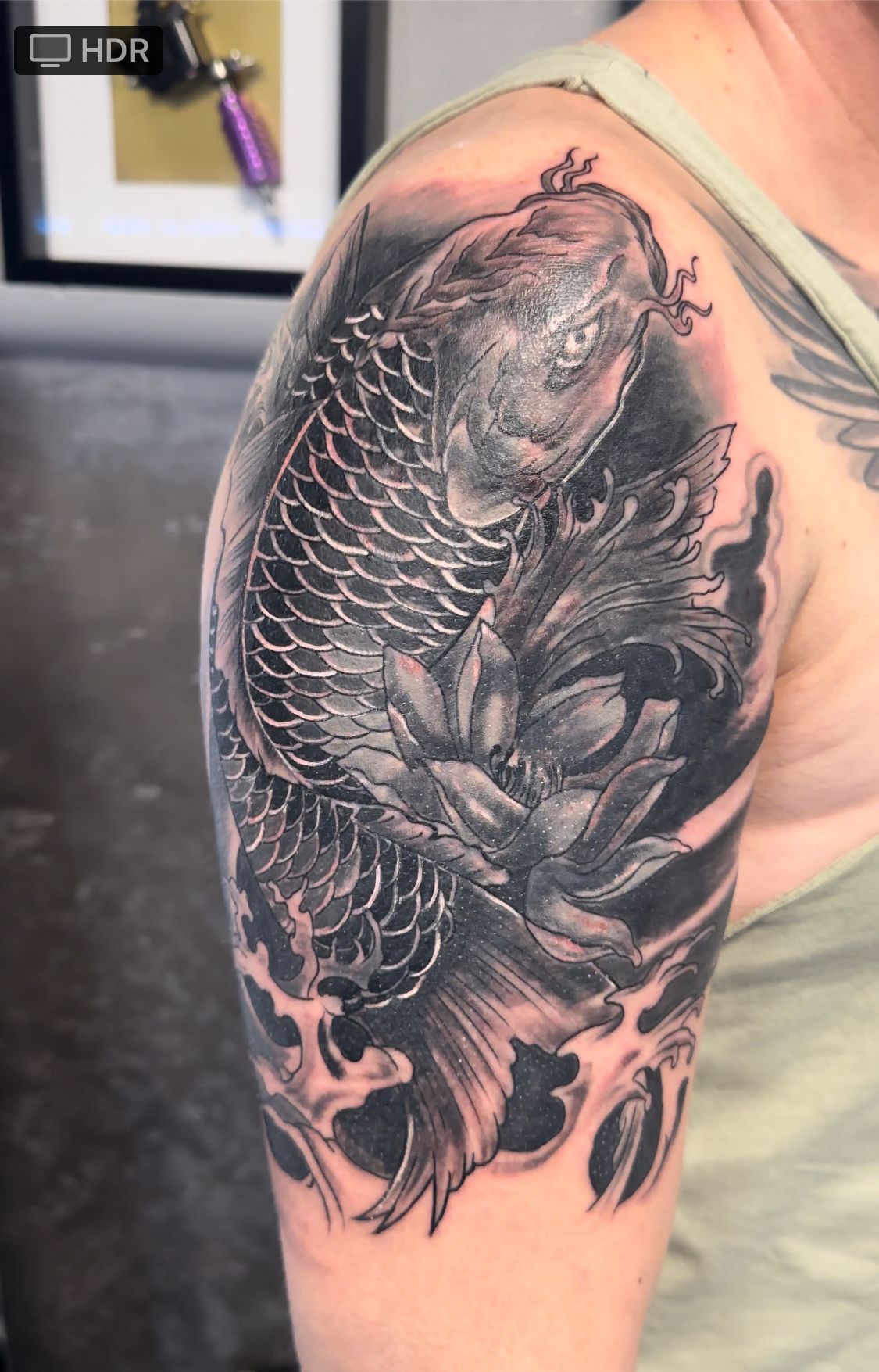 Eine Frau hat ein Fischtattoo auf ihrer Schulter.