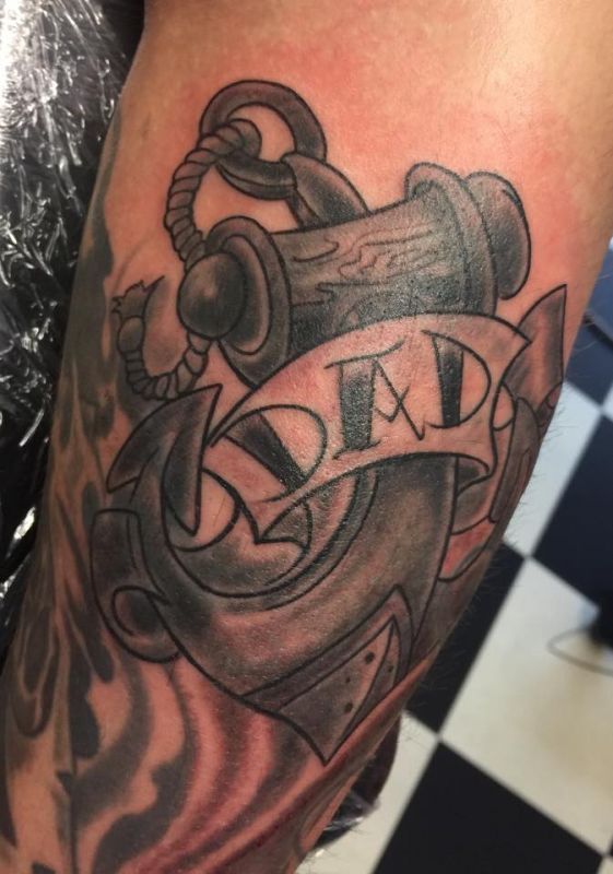 Ein Tattoo eines Ankers mit dem Wort „Dad“ darauf