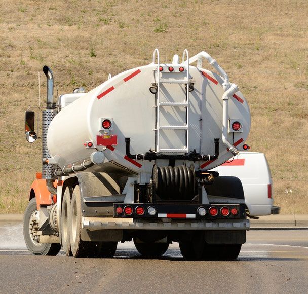 A White Water Tanker Truck Is Moving Down The Street — Porta-Vac in Proserpine, QLD