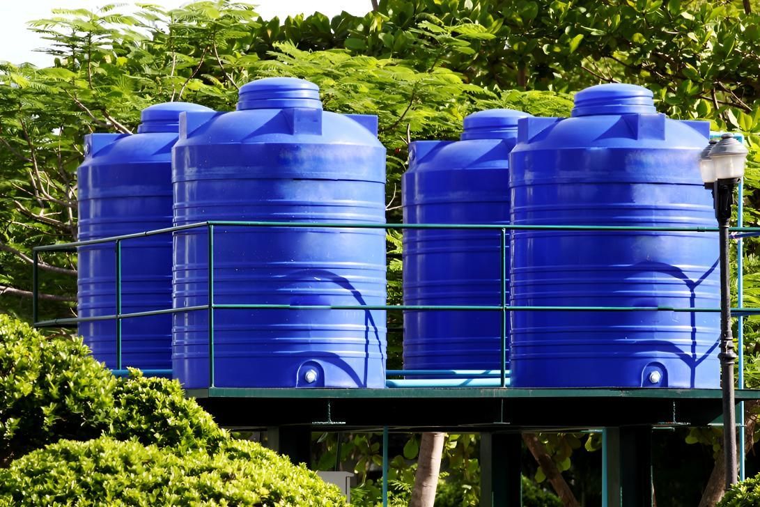 A Row Of Blue Water Tanks Are Sitting On Top Of A Platform In A Park — Porta-Vac in Bowen, QLD