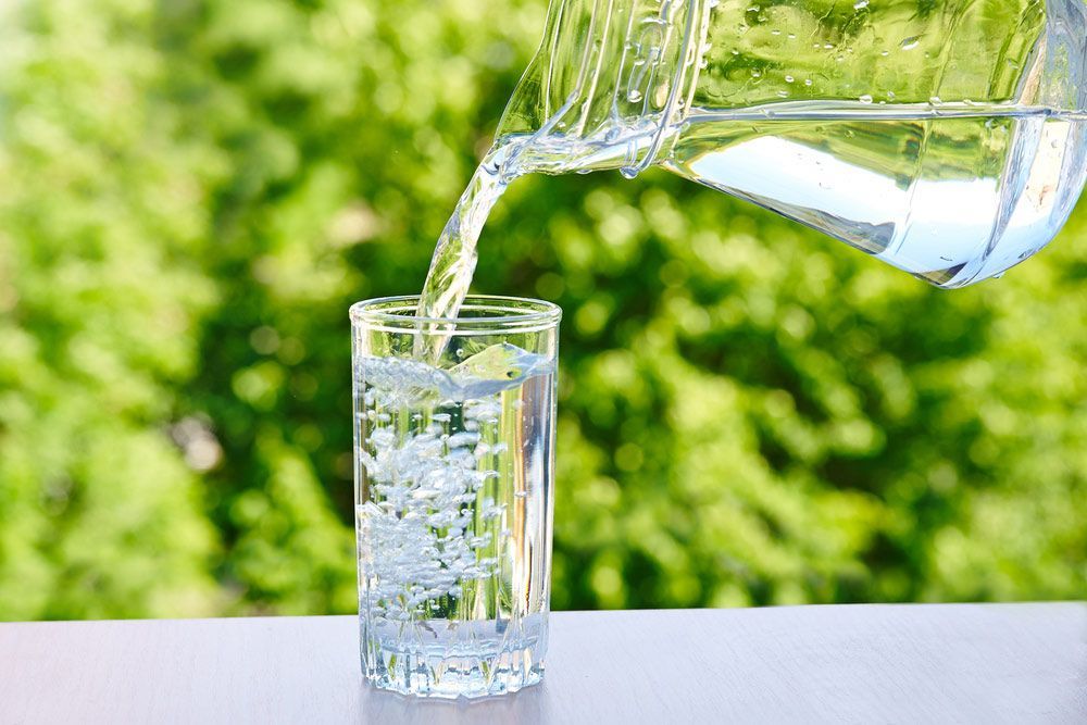 Drinking Water Is Poured From A Jug Into A Glass — Porta-Vac in Proserpine, QLD