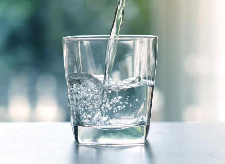 Close Up Pouring Purified Fresh Drink Water From The Bottle — Porta-Vac in Cannonvale, QLD