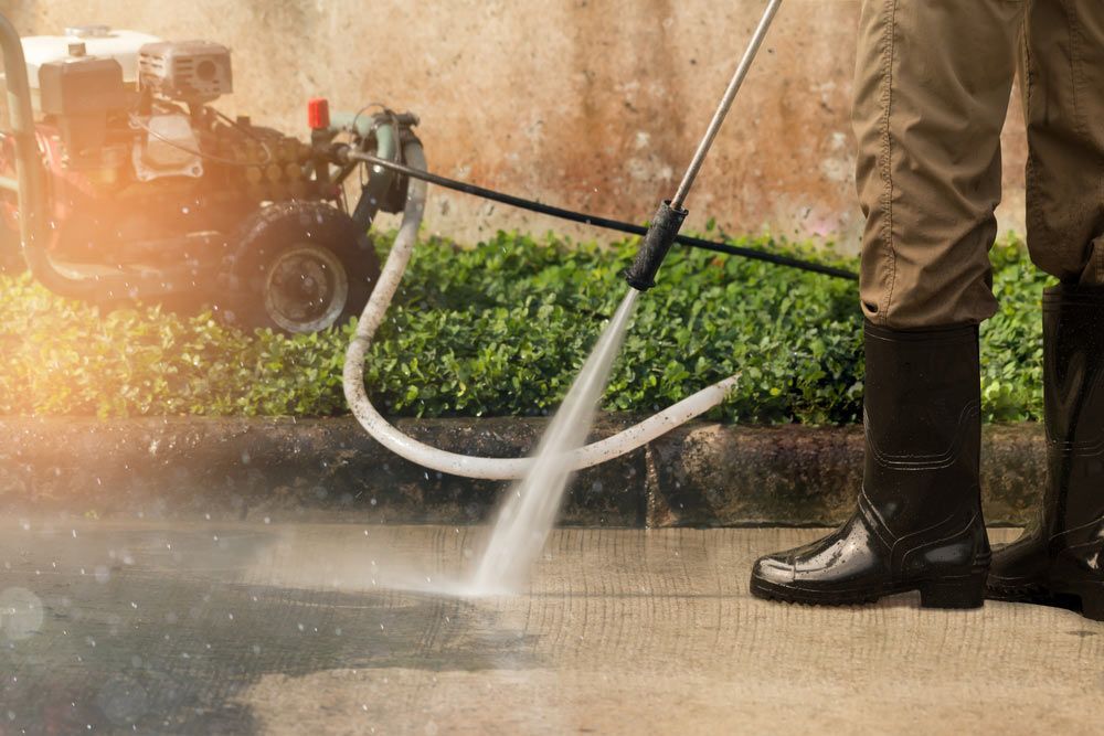 A Sidewalk Is Being Cleaned By A Person With A High-pressure Washer — Porta-Vac in Proserpine, QLD