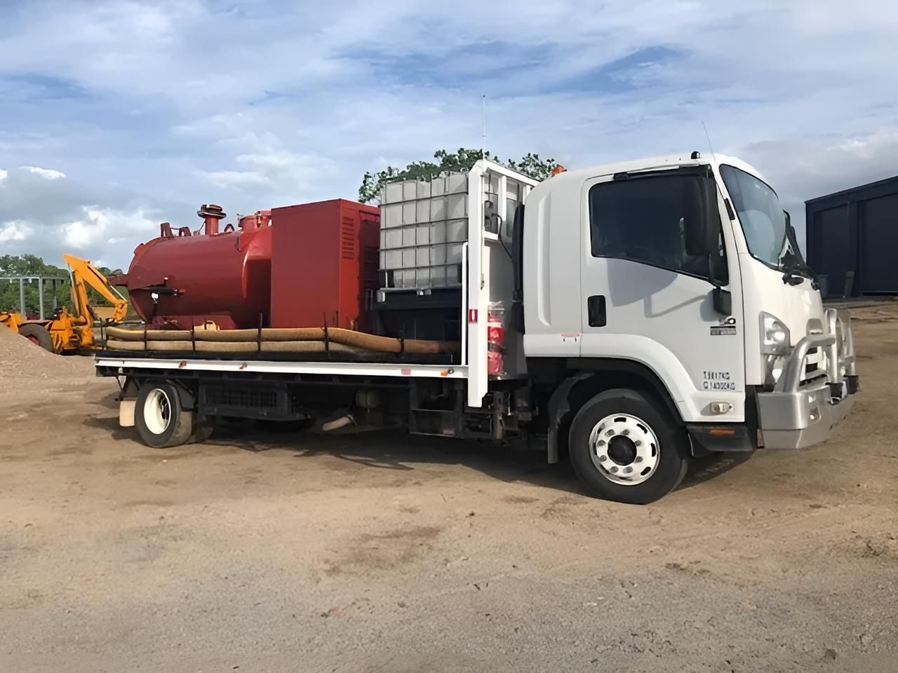 A White Truck With A Red Tank On The Back Is Parked In A Dirt Lot — Porta-Vac in Bowen, QLD
