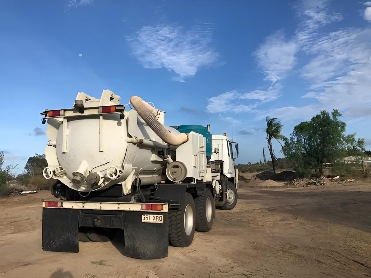 A Large White Truck Is Parked In A Dirt Field — Porta-Vac in Bowen, QLD
