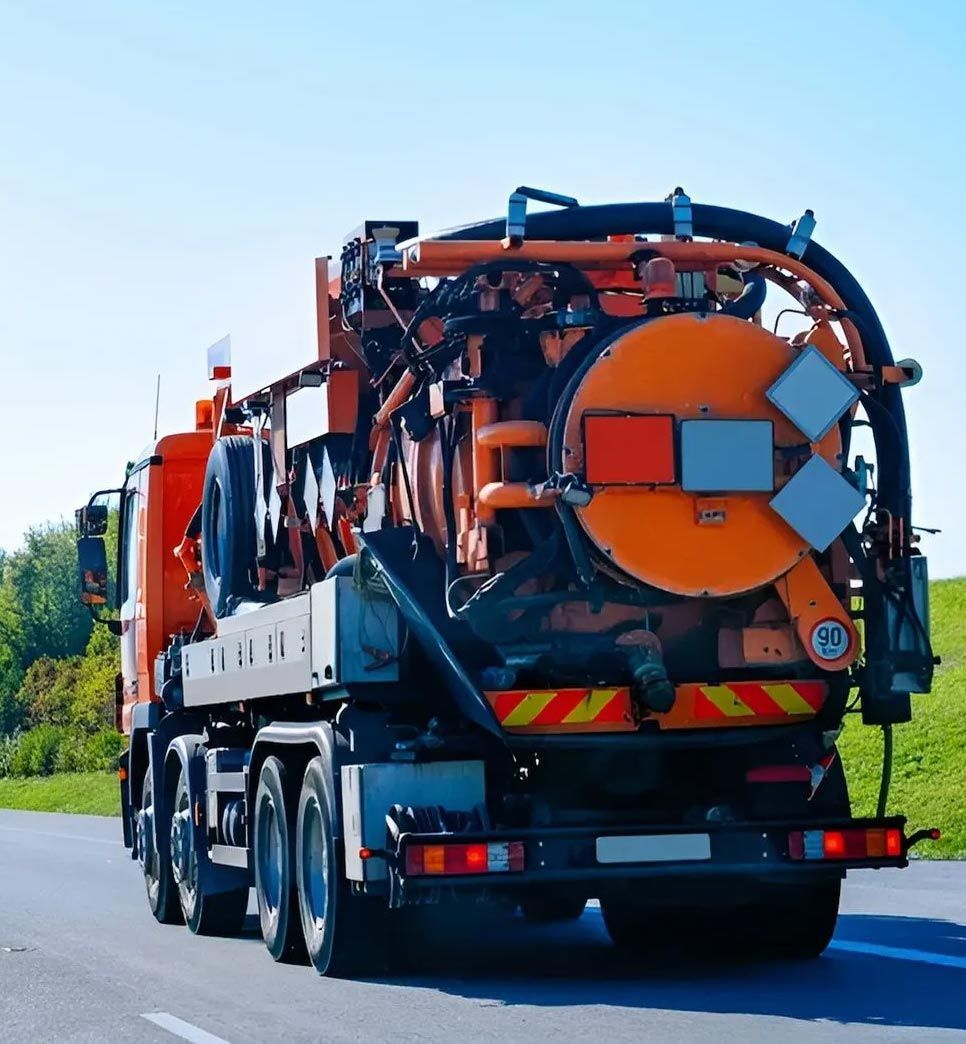 A Large Orange Truck Travels Along A Road