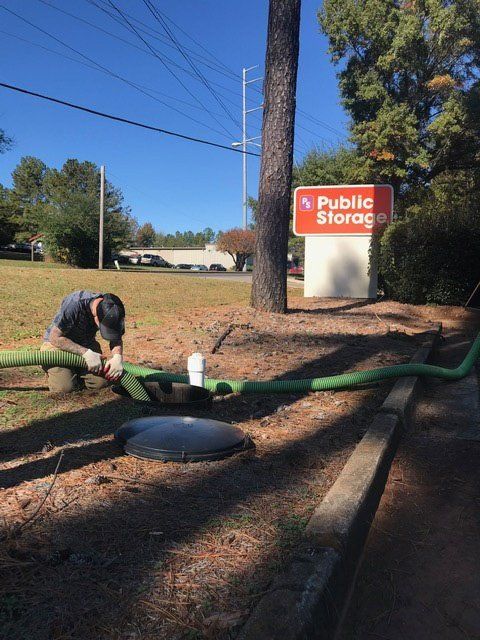 Man Fixing The Hose — Statham, GA — Affordable Septic Service
